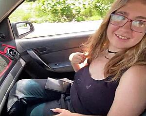 A young woman hitchhikes and gets a ride from a couple in a car